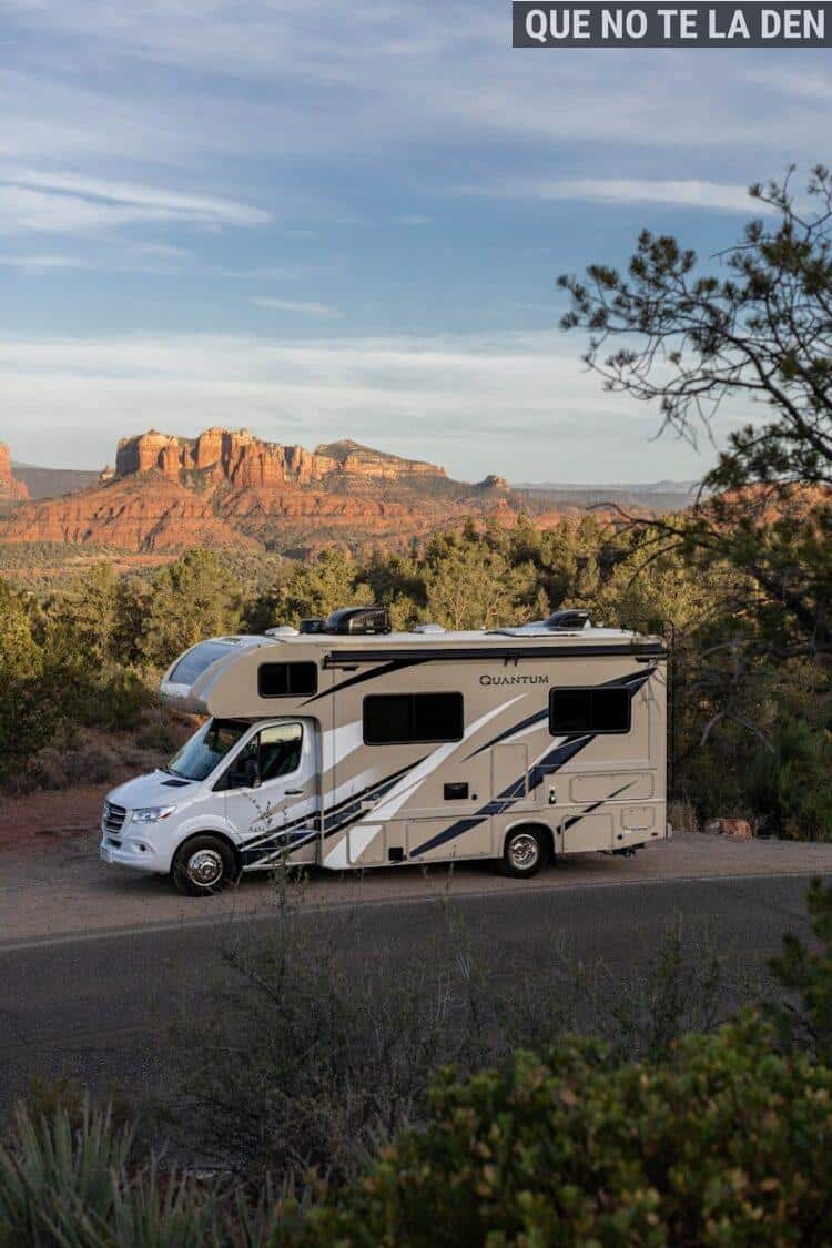 a white van parked on a road with trees and mountains in the background