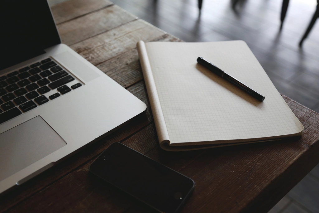 Cuaderno abierto con un bolígrafo sobre una mesa de trabajo
